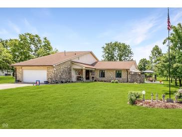 Beautiful stone home with an attached two-car garage and expansive front yard at 8111 Timberwood Dr, Plainfield, IN 46168