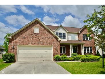 Charming brick home featuring a two-car garage, well-manicured lawn, and classic architectural details at 11850 Stepping Stone Dr, Fishers, IN 46037