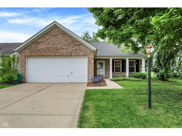 Charming brick home with a well-maintained lawn, attached garage, and inviting front porch at 12257 Driftstone Dr, Fishers, IN 46037