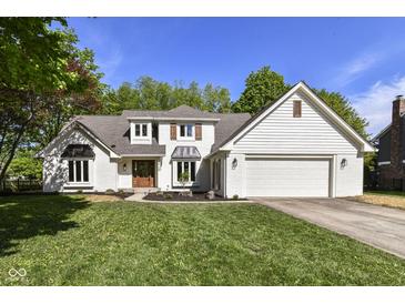 Charming two-story home with a well-manicured lawn, attached garage, and a welcoming, wooden front door at 14728 Adios Pass, Carmel, IN 46032