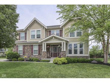 Charming two-story home featuring a stone facade, well-manicured lawn, and inviting front porch at 1476 Anon Ct, Greenwood, IN 46143