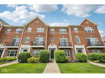 Charming brick townhouse featuring well-manicured landscaping and a classic architectural design at 15369 Mystic Rock Dr, Carmel, IN 46033