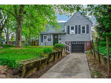 Charming two-story home featuring a landscaped yard and inviting curb appeal with a garage and well-maintained lawn at 1717 Hst W 10Th St, Anderson, IN 46016