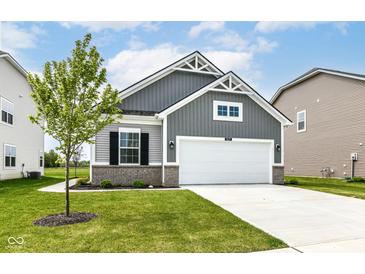 Charming home featuring a two-car garage, well-manicured lawn, and gray wood-look siding at 1829 James Pierce Dr, Shelbyville, IN 46176