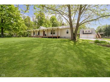 Charming home with a large front yard, mature tree, covered porch with a porch swing and an attached garage at 503 E Bunker Hill Rd, Mooresville, IN 46158