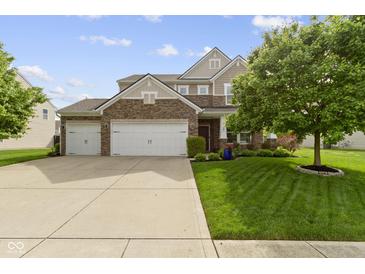 Charming two-story home with a three car garage, brick accents, and well-manicured lawn at 5593 Ralfe Rd, Indianapolis, IN 46234