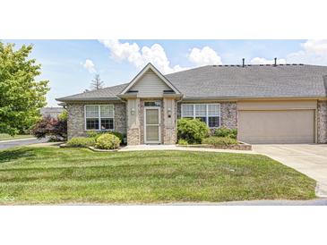Well-maintained home featuring a brick facade, an attached garage, green lawn, and manicured landscaping at 6816 Park Square Dr # C, Avon, IN 46123