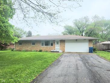 Charming brick ranch home with a long driveway and an attached two car garage at 7109 Chandler Dr, Indianapolis, IN 46217