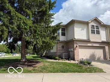 Charming two-story home featuring a well-manicured lawn, attached garage, and beautiful landscaping at 8002 Windham Lake Way # 33, Indianapolis, IN 46214