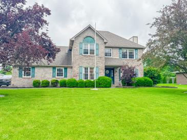 Charming two-story home with brick exterior, green shutters, and well-manicured lawn and landscaping at 8798 Surrey Dr, Pendleton, IN 46064