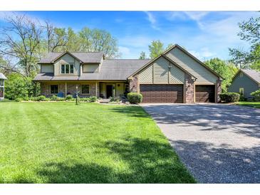 Charming home features an attached three car garage and a well manicured front lawn at 11471 Clarkston Rd, Zionsville, IN 46077