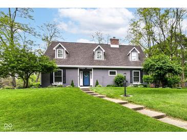 Charming gray home with a lush front lawn, beautiful landscaping and inviting blue front door at 11550 Clarkston Rd, Zionsville, IN 46077