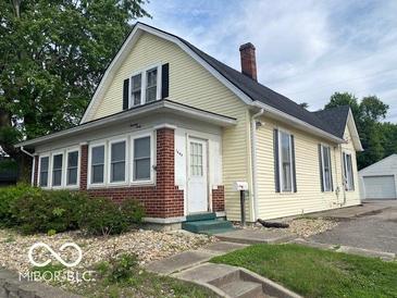 Charming two-story home with a brick foundation, yellow siding, and a well-maintained front yard at 1440 E Morgan E St, Martinsville, IN 46151