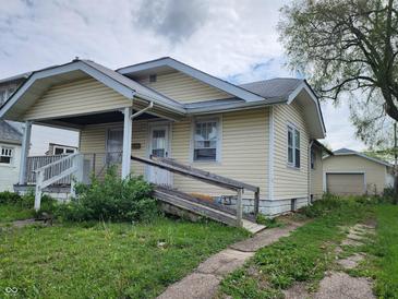 Charming single-story home featuring vinyl siding, a covered porch, a ramp, and a detached garage in the back at 2806 Jefferson St, Anderson, IN 46016