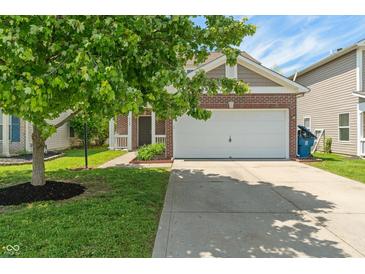 Charming home featuring a two-car garage, brick accents, and a beautifully landscaped front yard with a mature tree at 4136 Orchard Valley Ln, Indianapolis, IN 46235