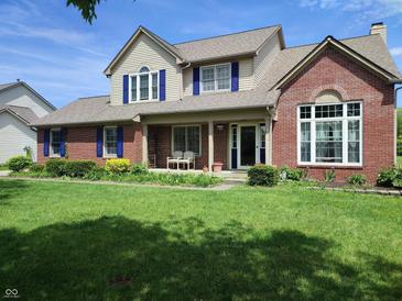 Charming two-story home with brick and siding, blue shutters, covered porch, and well-manicured lawn at 4719 Arabian Run, Indianapolis, IN 46228