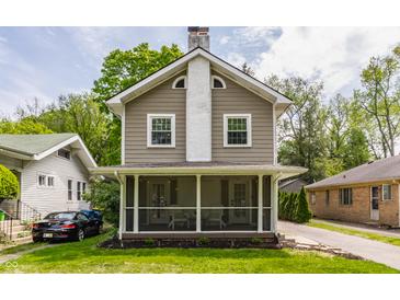 Charming two-story home featuring a screened-in front porch and classic architectural details at 5829 Broadway St, Indianapolis, IN 46220