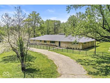 Charming single-story home with a long driveway and fenced front yard, perfect for a Gathering at 6464 Whitley Ln, Indianapolis, IN 46260