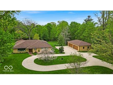An impressive single story home with circle drive and three car detached garage on a landscaped lawn at 6465 Lawrence Dr, Indianapolis, IN 46226