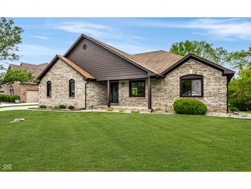 Charming single-story brick home with a well-manicured lawn and inviting front porch at 7665 Stones River Ct, Indianapolis, IN 46259