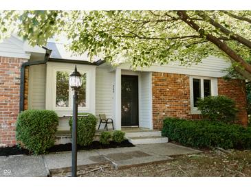 Home exterior boasts a cozy front porch with brick detail, decorative lamp, and manicured landscaping at 780 Wilson Terrace Ct, Carmel, IN 46032