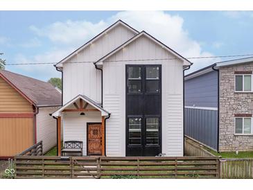 Modern two-story home with white siding, a dark window accent, and a rustic wood fence at 1009 Harrison St, Indianapolis, IN 46202