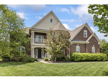 Charming two-story brick home featuring a welcoming front porch and beautifully manicured lawn at 10504 Ruxton Ct, Fishers, IN 46040
