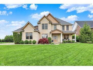 Beautiful two story brick home with a manicured lawn, landscaping and a welcoming front porch at 12152 Teal Ln, Carmel, IN 46032