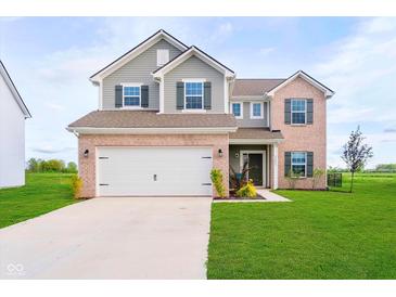 Charming two-story home with a well-manicured lawn, a two-car garage, and beautiful brick and siding accents at 17951 Paula Walk, Westfield, IN 46074