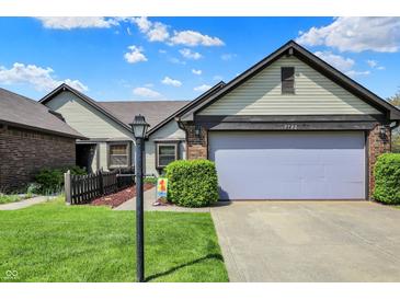 Charming home featuring a two-car garage, well-kept lawn, and lovely landscaping, perfect for suburban living at 7702 Justin Ln, Indianapolis, IN 46219