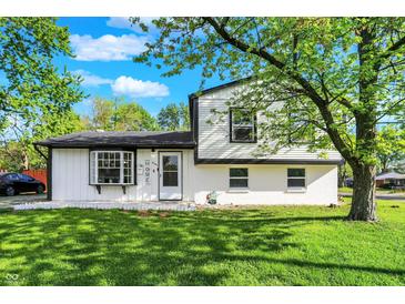 Charming two-story home with freshly cut lawn, bright white siding, black trim, and lovely curb appeal at 8103 Laughlin Dr, Indianapolis, IN 46219