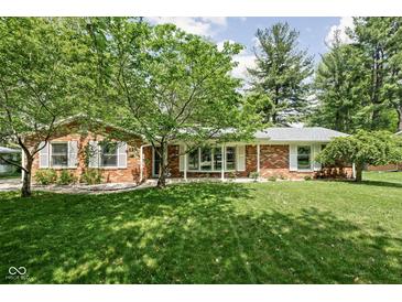 Charming brick ranch-style home featuring a well-manicured lawn and mature trees at 818 Merry Ln, Greenwood, IN 46142