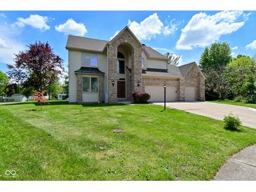 Inviting two-story home with a three car garage and landscaped front yard at 8627 Lansdowne Dr, Fishers, IN 46038