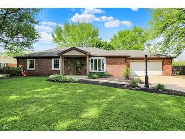 Charming red brick ranch home featuring a manicured lawn, bay window and attached garage at 8834 W 1050 S, Fortville, IN 46040