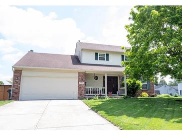 Charming two-story home featuring a brick-and-vinyl facade, attached garage, and well-manicured front yard at 905 N Main St, Fortville, IN 46040