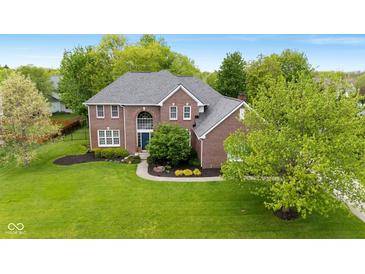 Charming two-story brick home featuring a manicured front lawn and mature trees at 13248 Blacktern Way, Carmel, IN 46033
