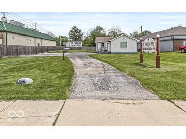 Charming single-story home with a well-maintained lawn and long driveway entrance at 1391 N Shadeland Ave, Indianapolis, IN 46219