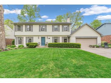 Charming two-story home with a well-manicured lawn and a beautiful blue front door at 4232 Briarwood Dr, Indianapolis, IN 46250