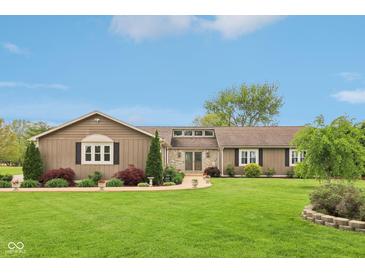 Charming ranch home featuring professional landscaping, covered entry, stone accents and a sprawling front lawn at 4732 Ferguson Rd, Indianapolis, IN 46239