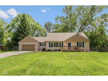 Charming single-story home with a manicured lawn, lovely front porch, and attached garage, perfect for suburban living at 5015 E 70Th E St, Indianapolis, IN 46220