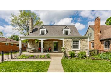 Charming stone home with a welcoming front porch and well-manicured lawn at 5224 Boulevard Pl, Indianapolis, IN 46208