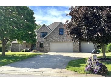 Charming two-story brick home featuring an attached two-car garage and a well-maintained lawn at 941 W Barouche, Pendleton, IN 46064