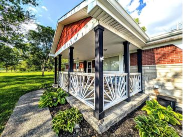 Inviting covered front porch with stylish railing and well-maintained landscaping at 10751 N Kitchen Rd, Mooresville, IN 46158