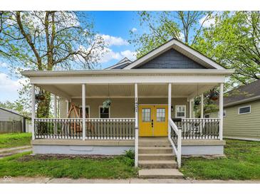 Charming home featuring a welcoming front porch with black railing and bright yellow front door at 1421 Laurel St, Indianapolis, IN 46203