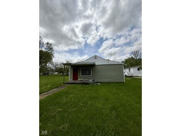 Cozy single-story home featuring a red front door and ample green lawn space at 1503 E 20Th St, Muncie, IN 47302