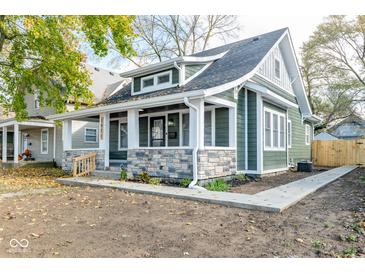 Charming home featuring stone accents, fresh landscaping, and a welcoming front porch at 1921 N Dexter St, Indianapolis, IN 46202