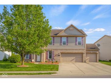 Charming two-story home with brick accents, tidy landscaping, and an attached two-car garage at 1969 Westminster Pl, Columbus, IN 47201