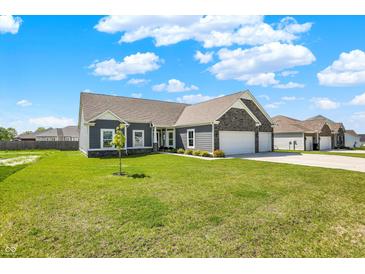 Charming single-story home with a gray exterior, stone accents, and a well-manicured lawn on a sunny day at 49 Manchester Dr, Trafalgar, IN 46181