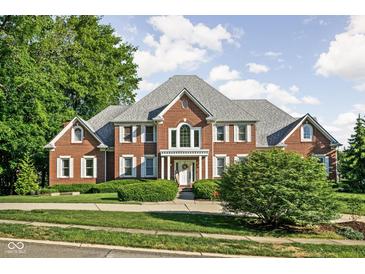 Stunning two-story brick home featuring a symmetrical design, well-manicured lawn, and mature trees at 4956 Waterside Cir, Carmel, IN 46033