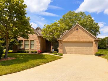 Charming brick home featuring a well-manicured lawn, beautiful trees, and a spacious two-car garage at 5190 Pursel Ln, Carmel, IN 46033